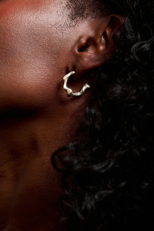 Boucle d'oreille Spira Synonys en argent 925, portée sur une oreille. Bijou fait main, collection Corail éthique.