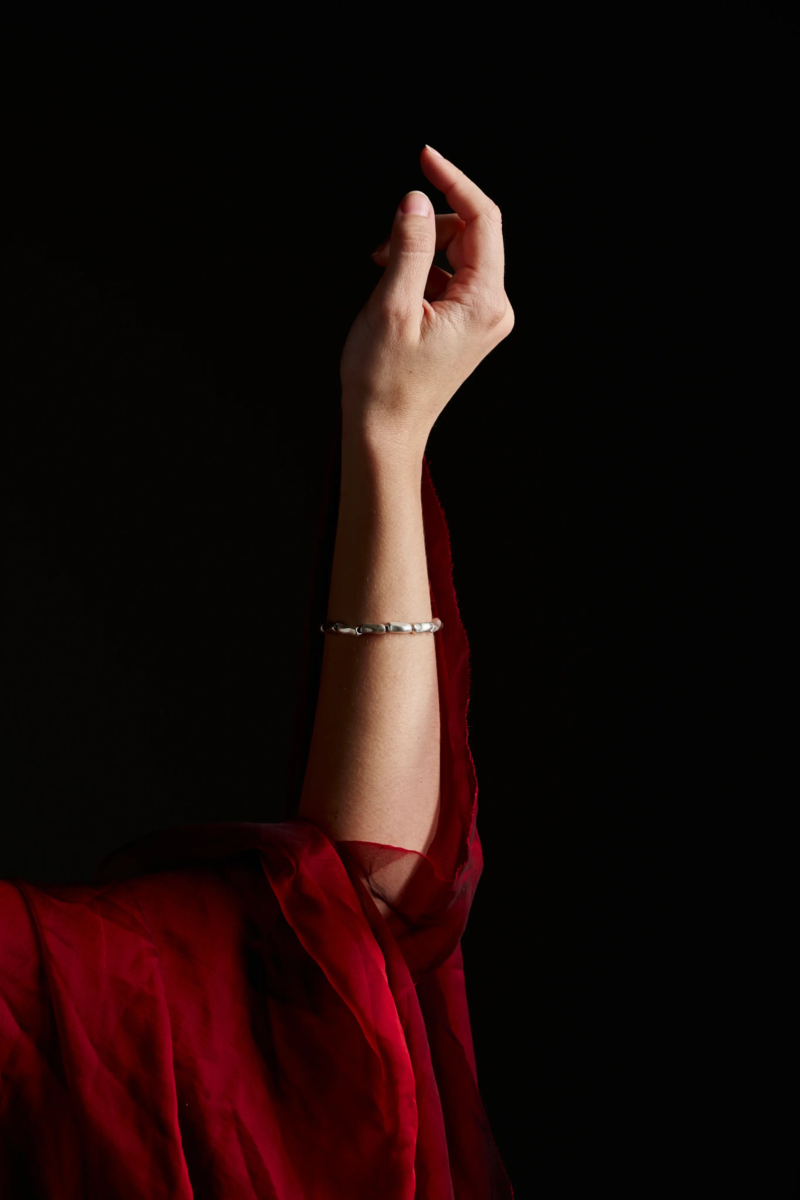 Femme portant le bracelet Fracta en argent au bras. Bijou artisanal et élégant.