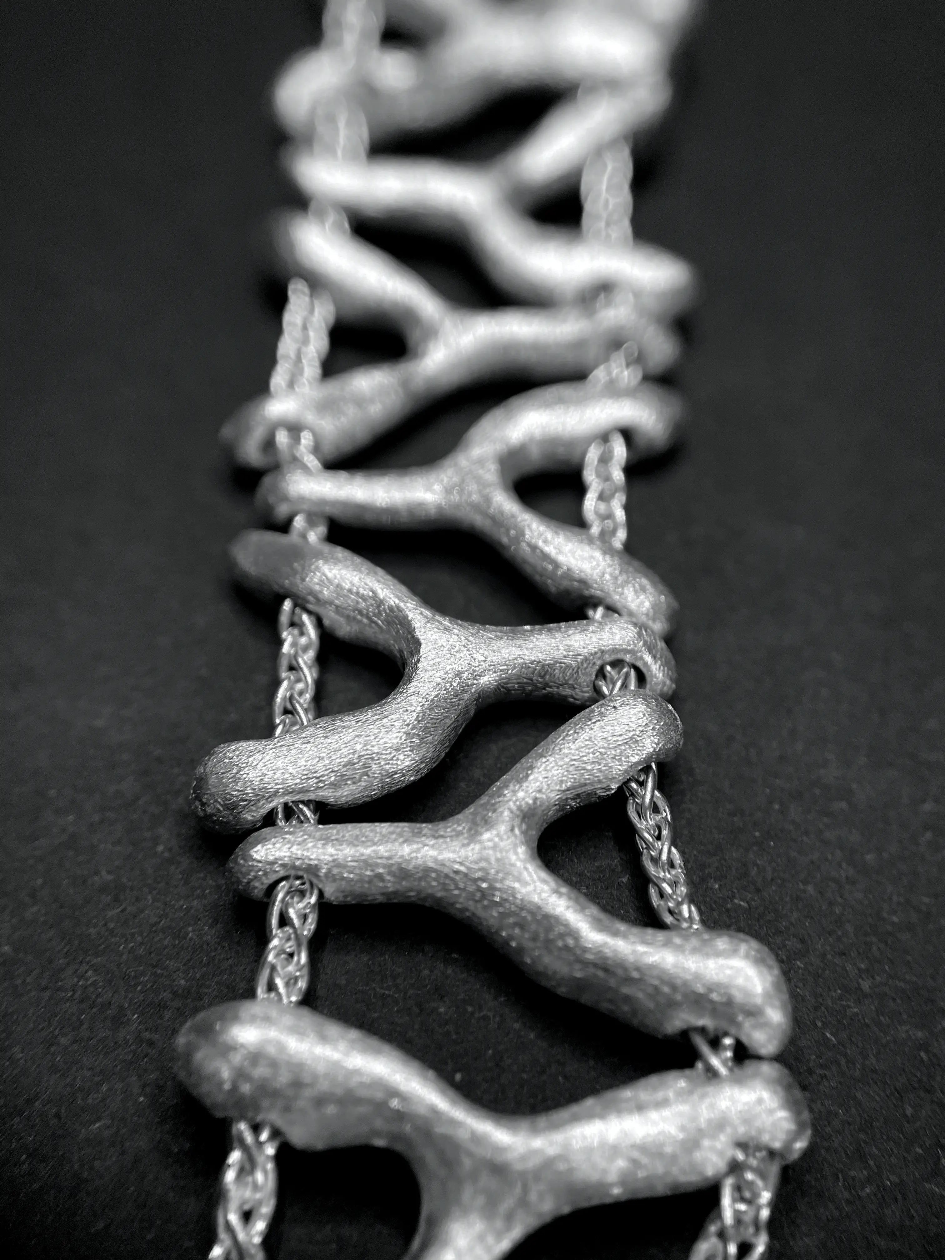 Macro du bracelet Isopora, montrant le détail des perles d'argent sculptées.