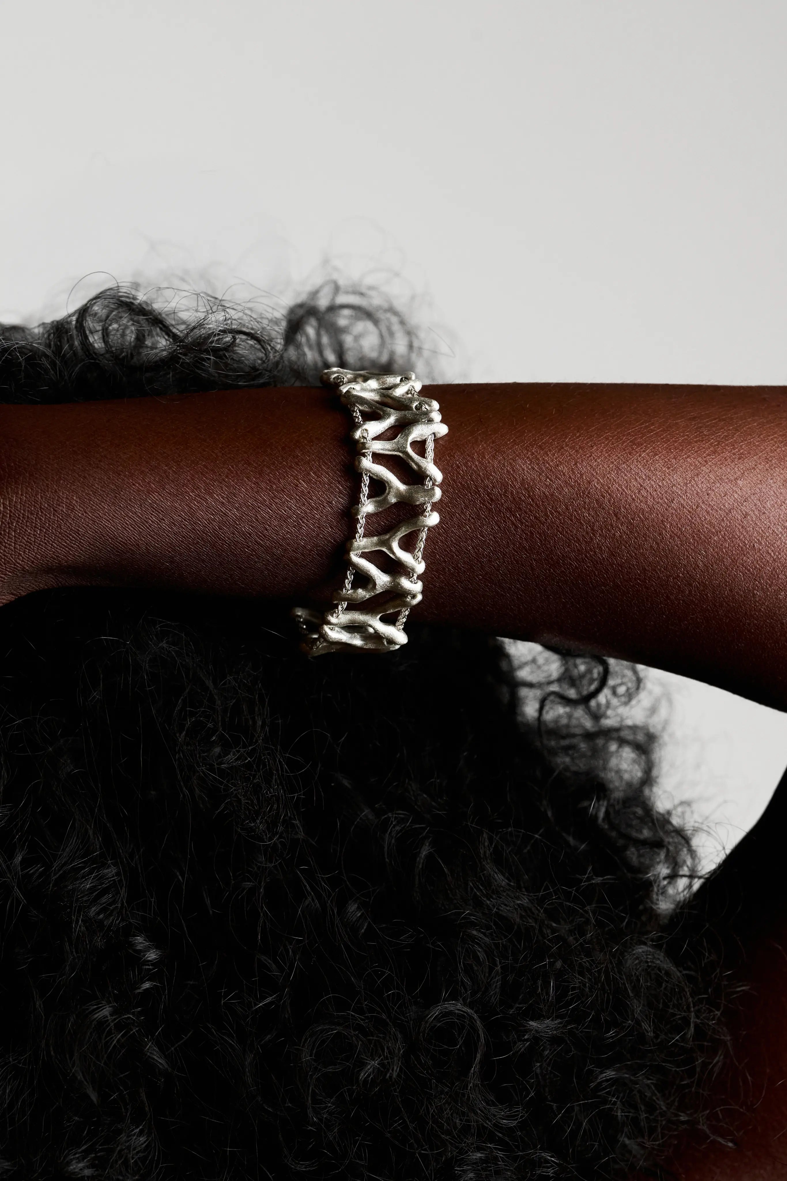 Vue de la main portant le bracelet Isopora et montrant le design ajouré.