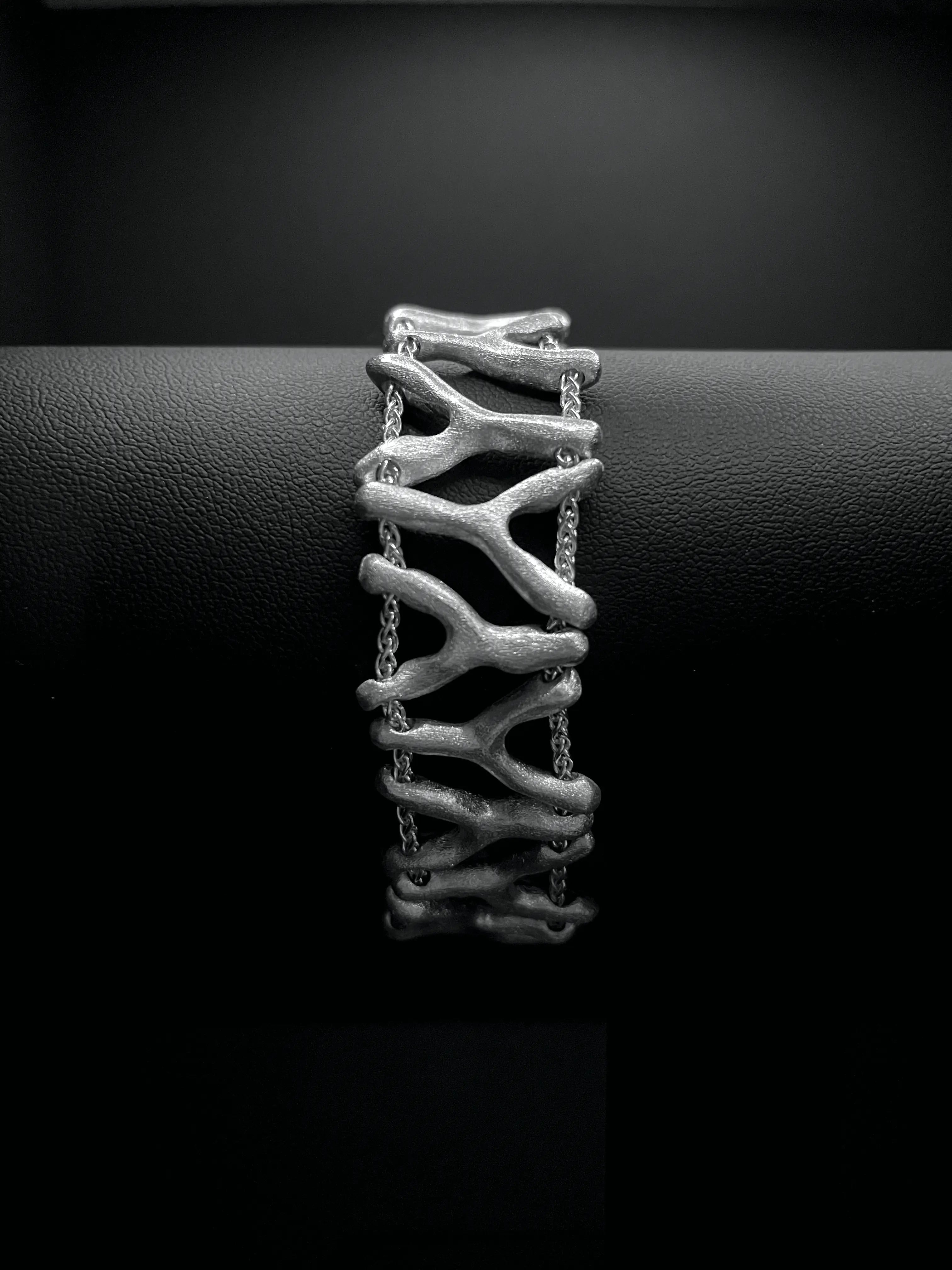 Bracelet Isopora en argent 925, design ajouré, sur fond noir.