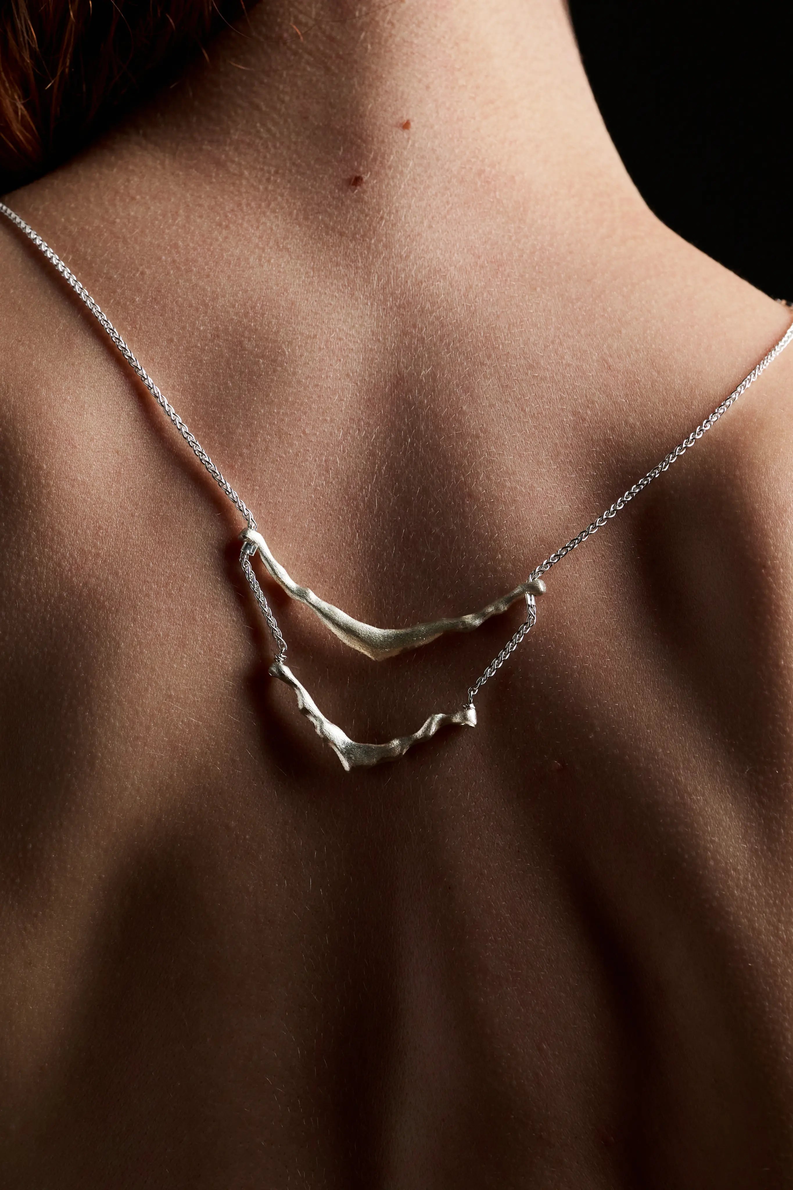 Femme de dos portant le collier de dos Exo en argent 925. Bijou de dos éthique.