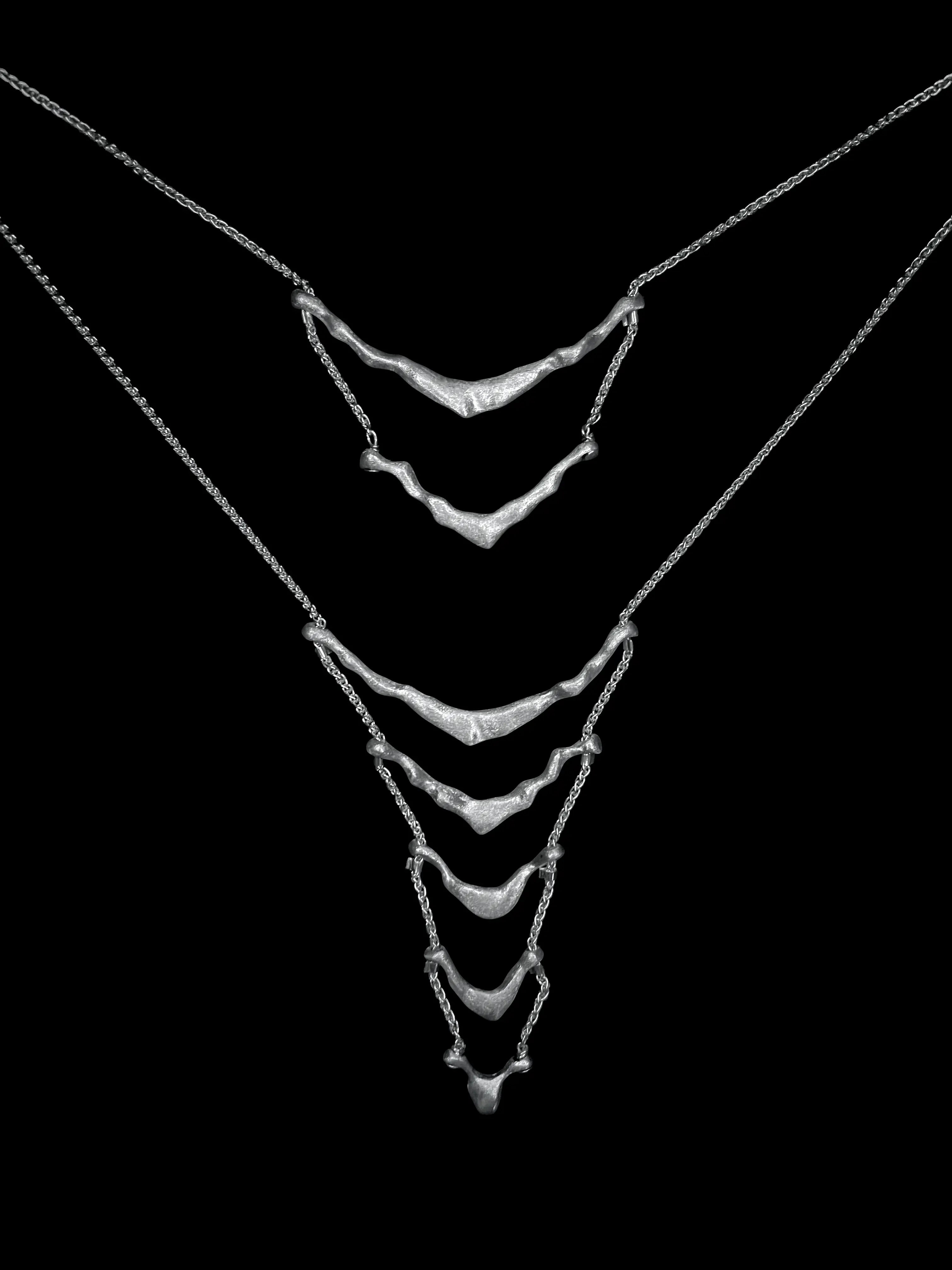 Vue de face du collier de dos Exo Synonys en argent 925 sur buste noir. Bijou fait main.