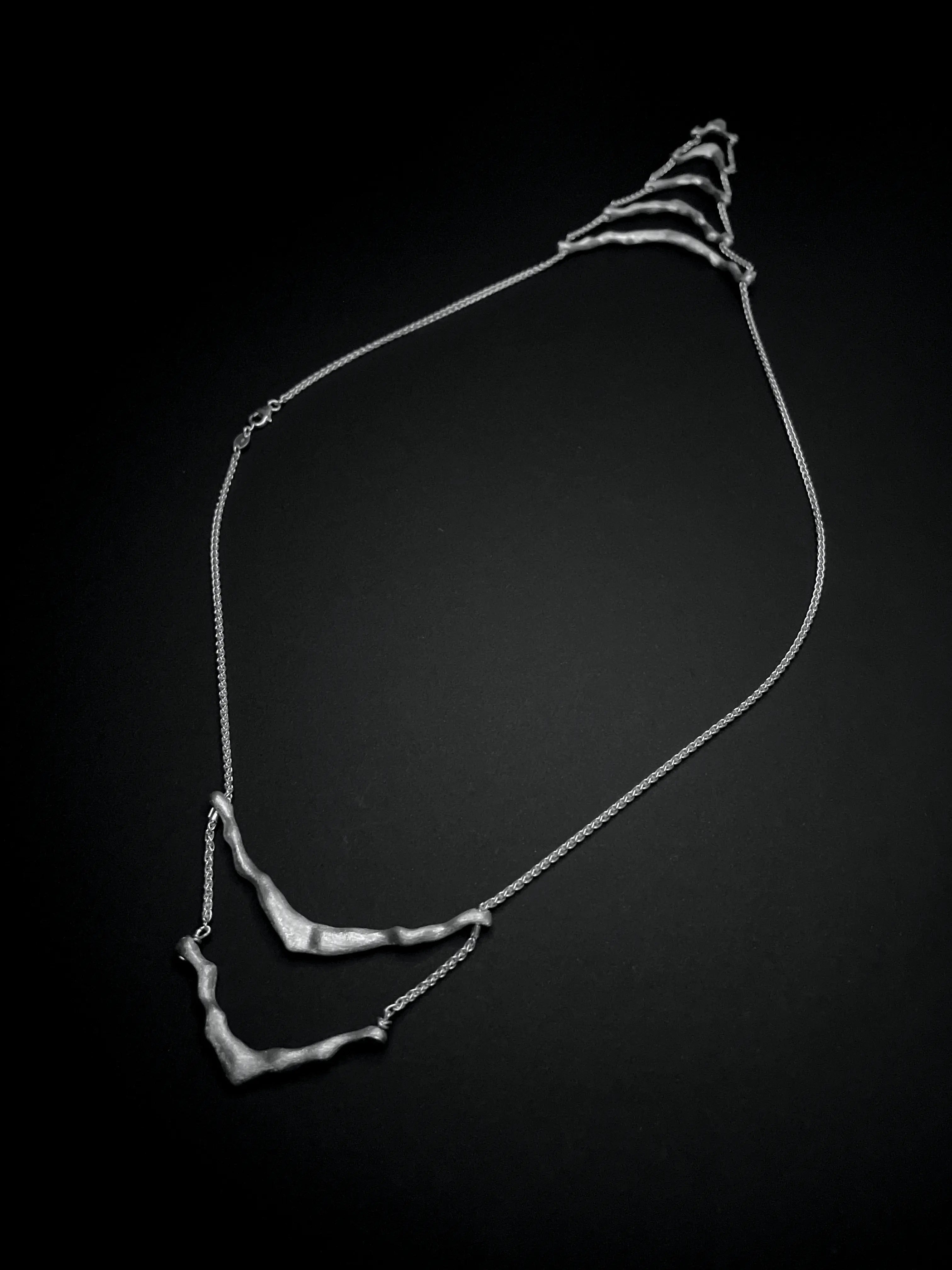 Vue détaillée du collier de dos Exo en argent sur fond noir. Collection Corail éthique.