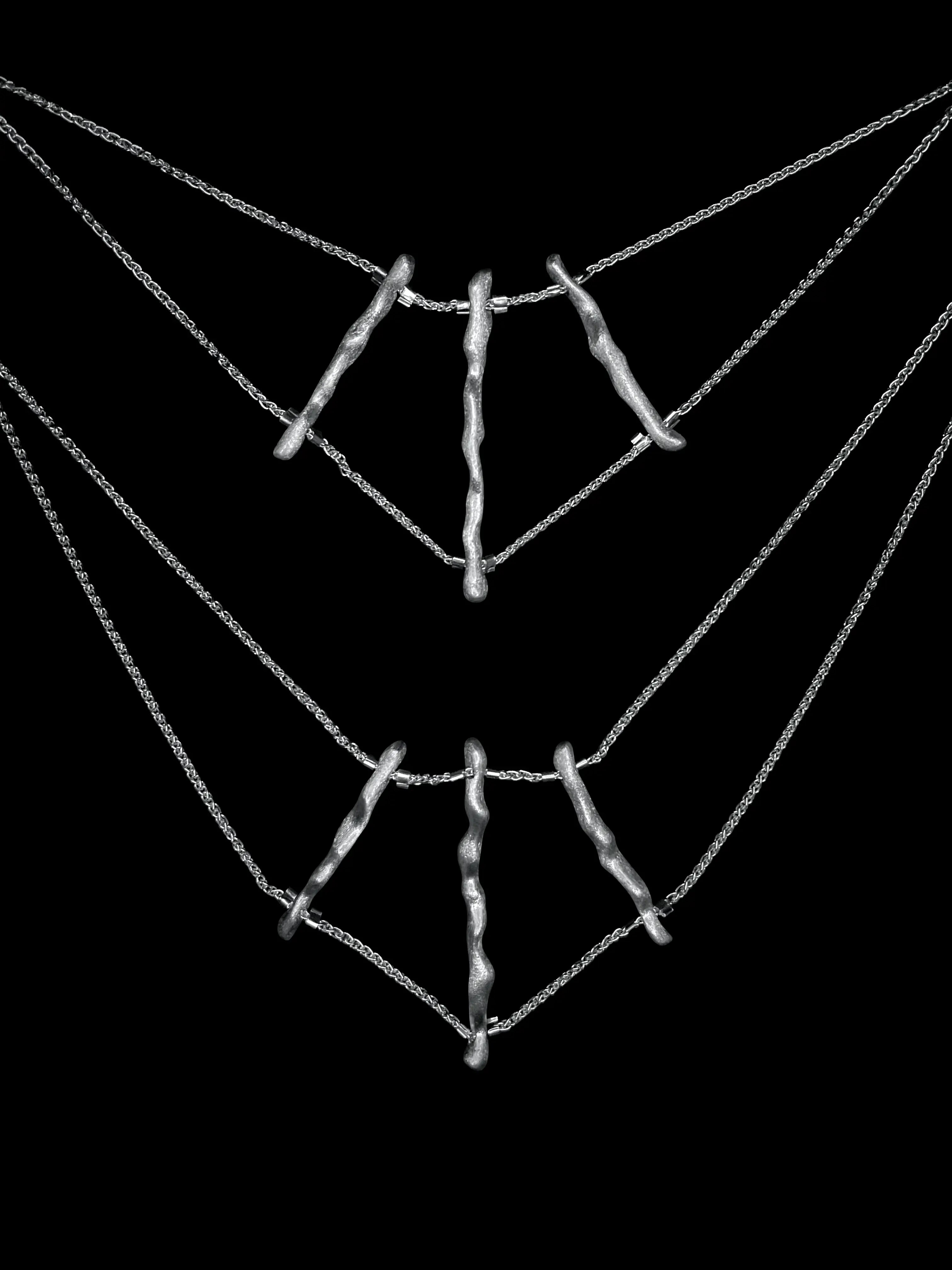 Vue produit du collier de dos Osso Synonys en argent 925 sur fond sombre. Bijou fait main.