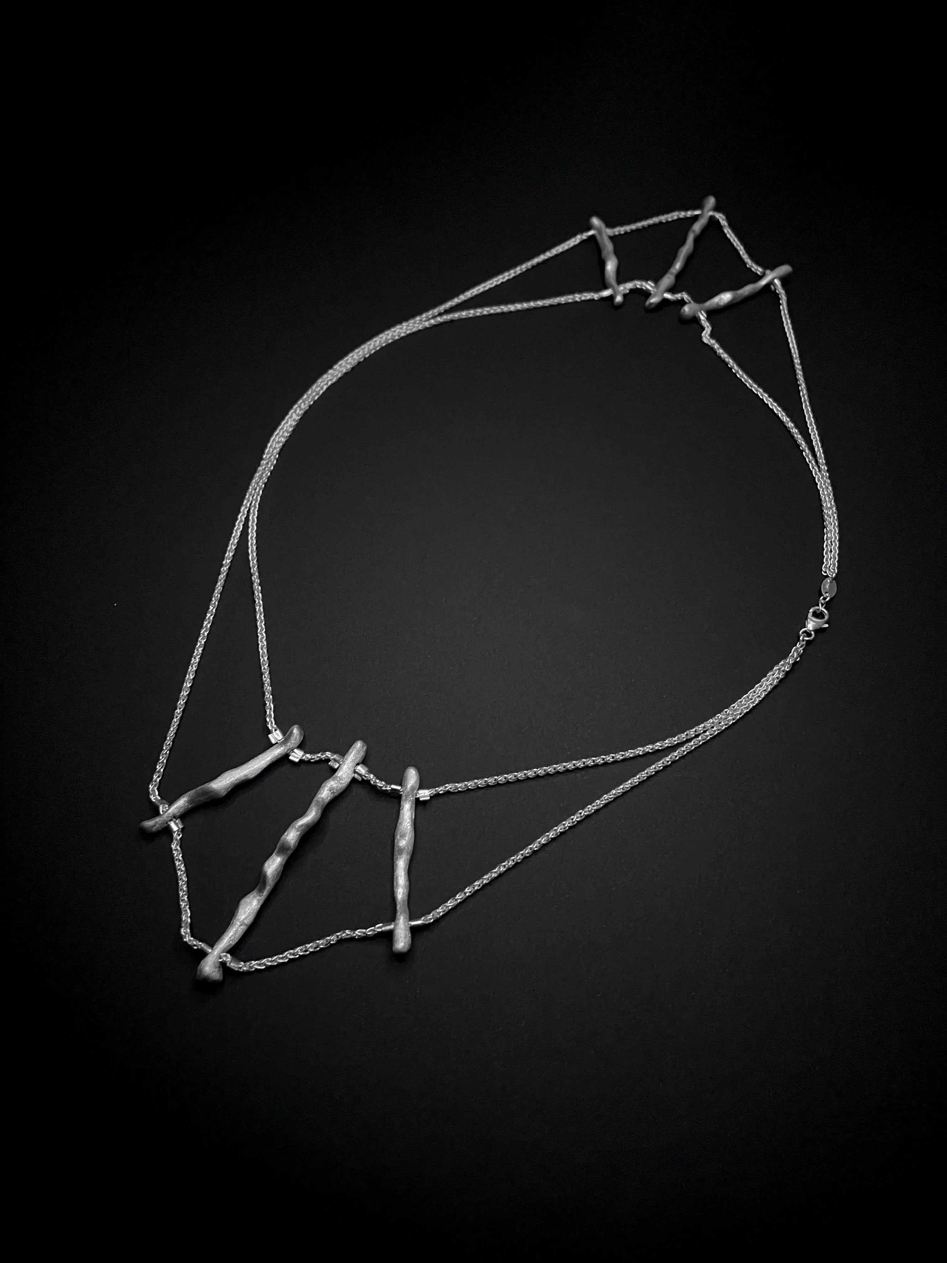 Vue détaillée du collier de dos Osso en argent 925, forme géométrique inspirée du corail.