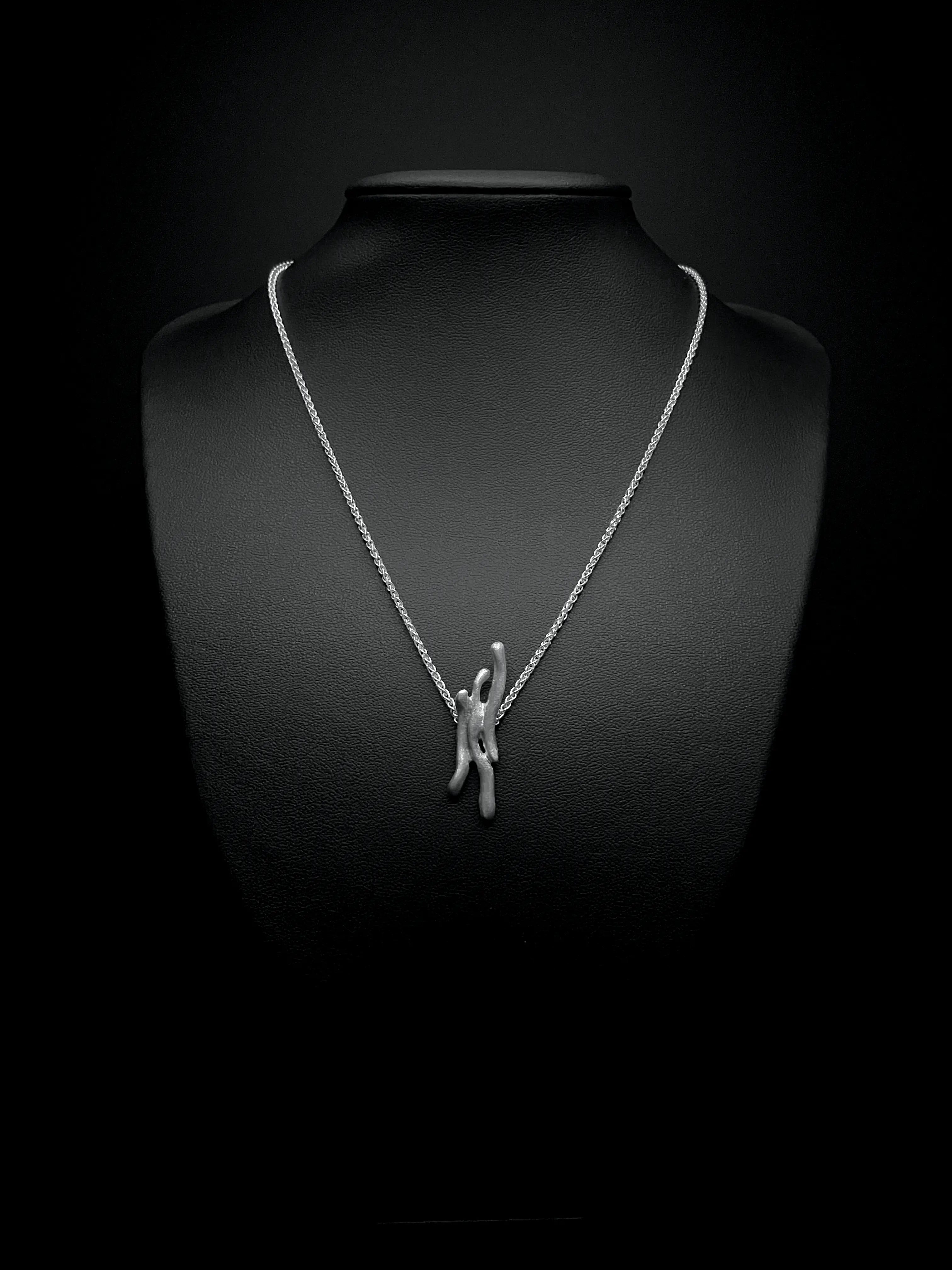 Portrait de profil d'un mannequin portant le collier Dusa en argent 925. Chaîne fine et pendentif.