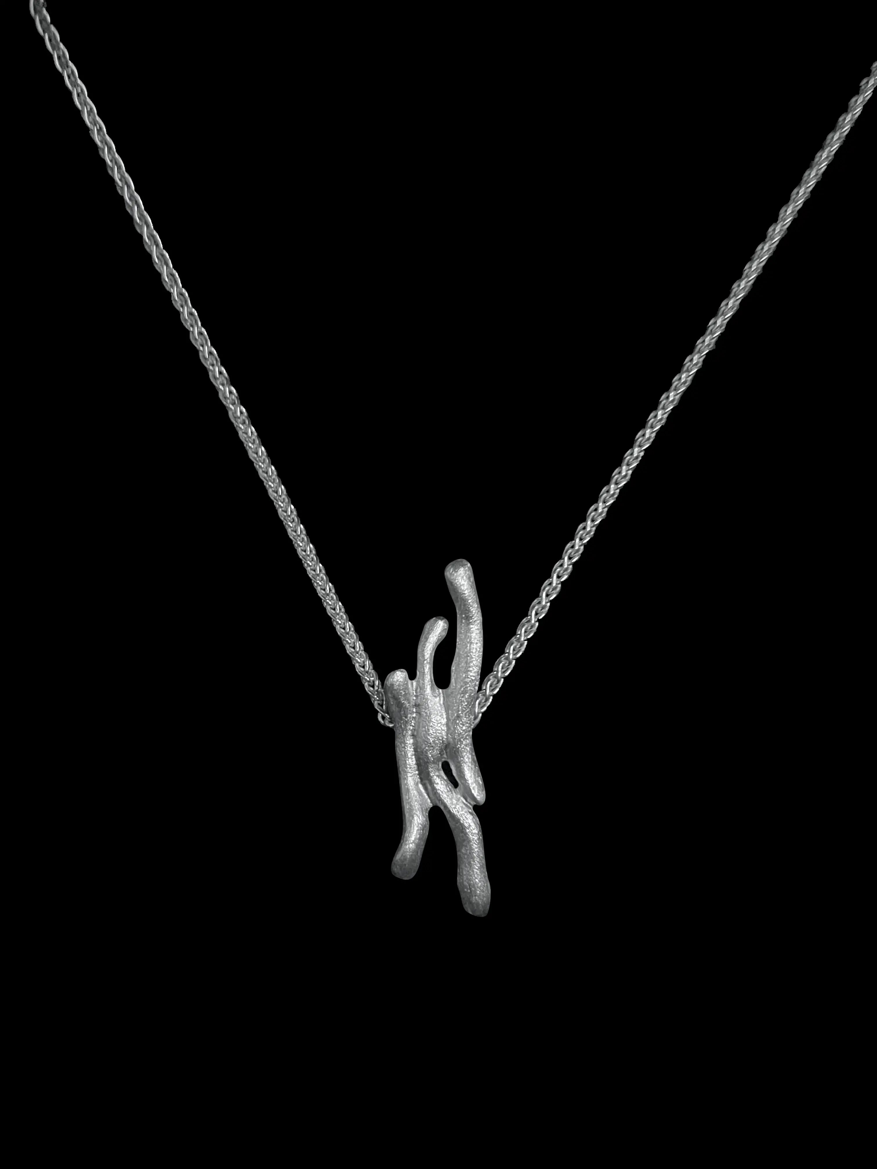 Vue complète du collier Dusa en argent 925 sur fond noir. Design fait main, perles d'argent.