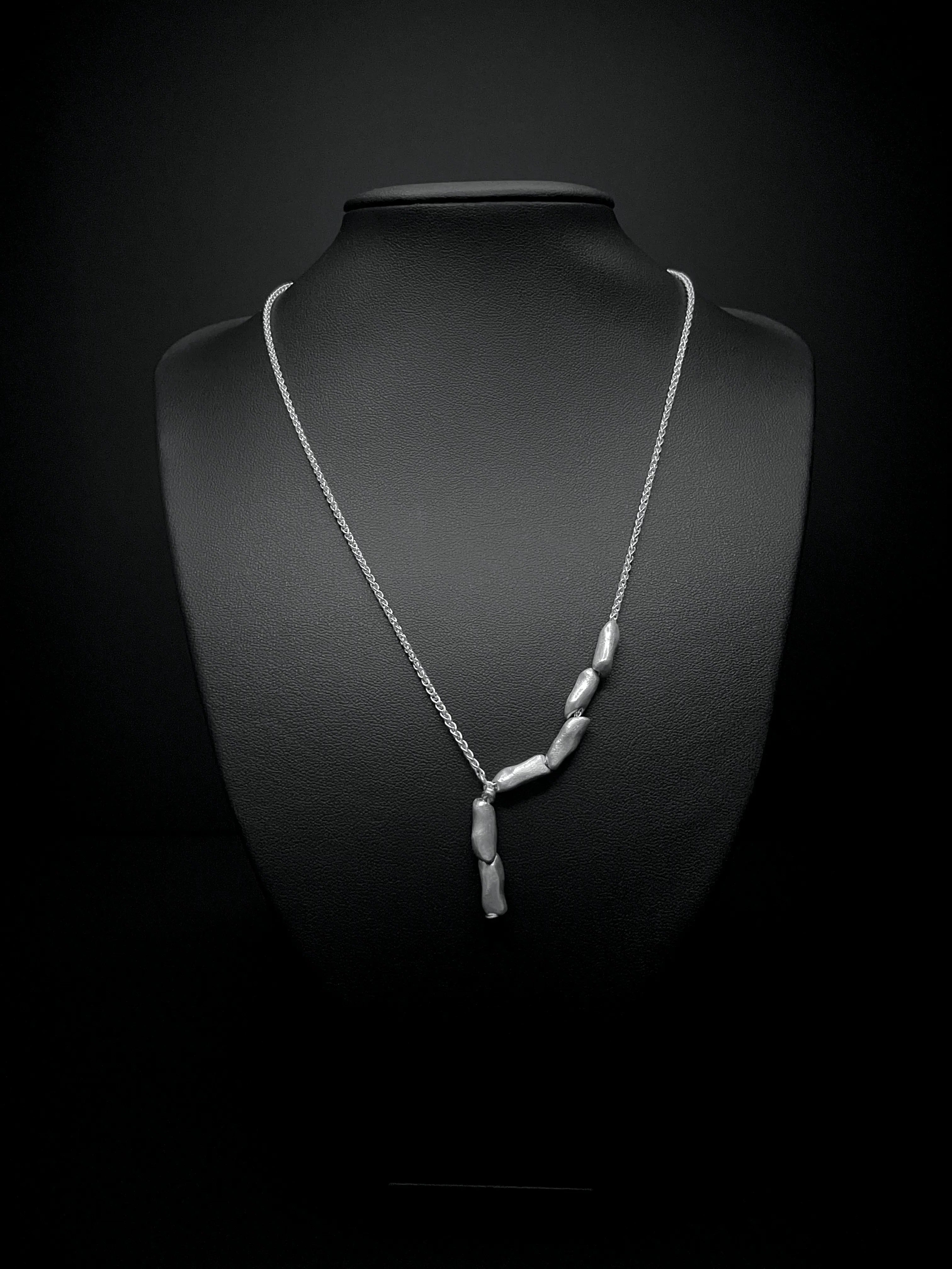 Vue du pendentif du collier Fracta avec chaîne. Bijou fait main par Synonys.