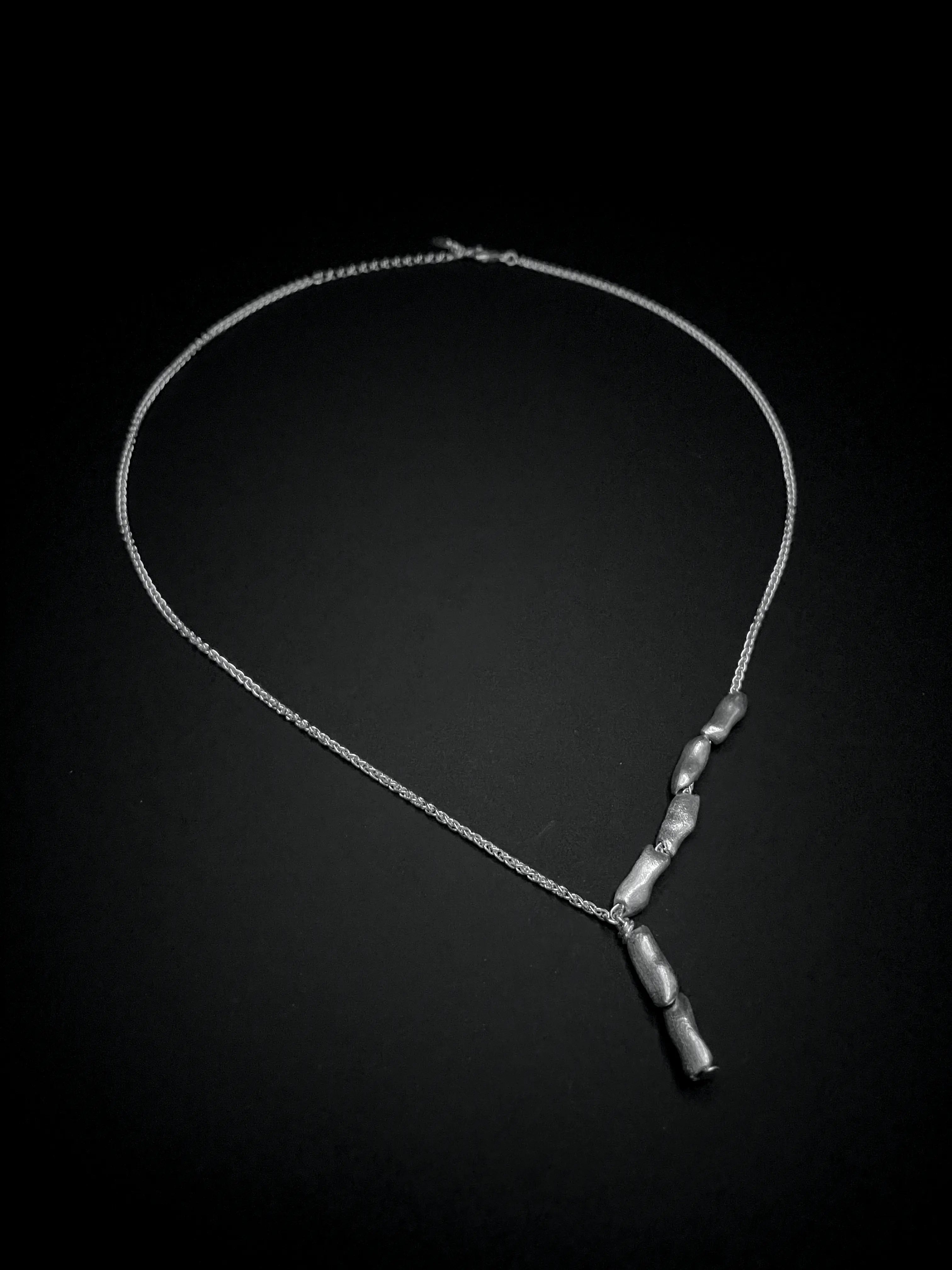 Gros plan du pendentif du collier Fracta en argent. Collection Corail éthique.