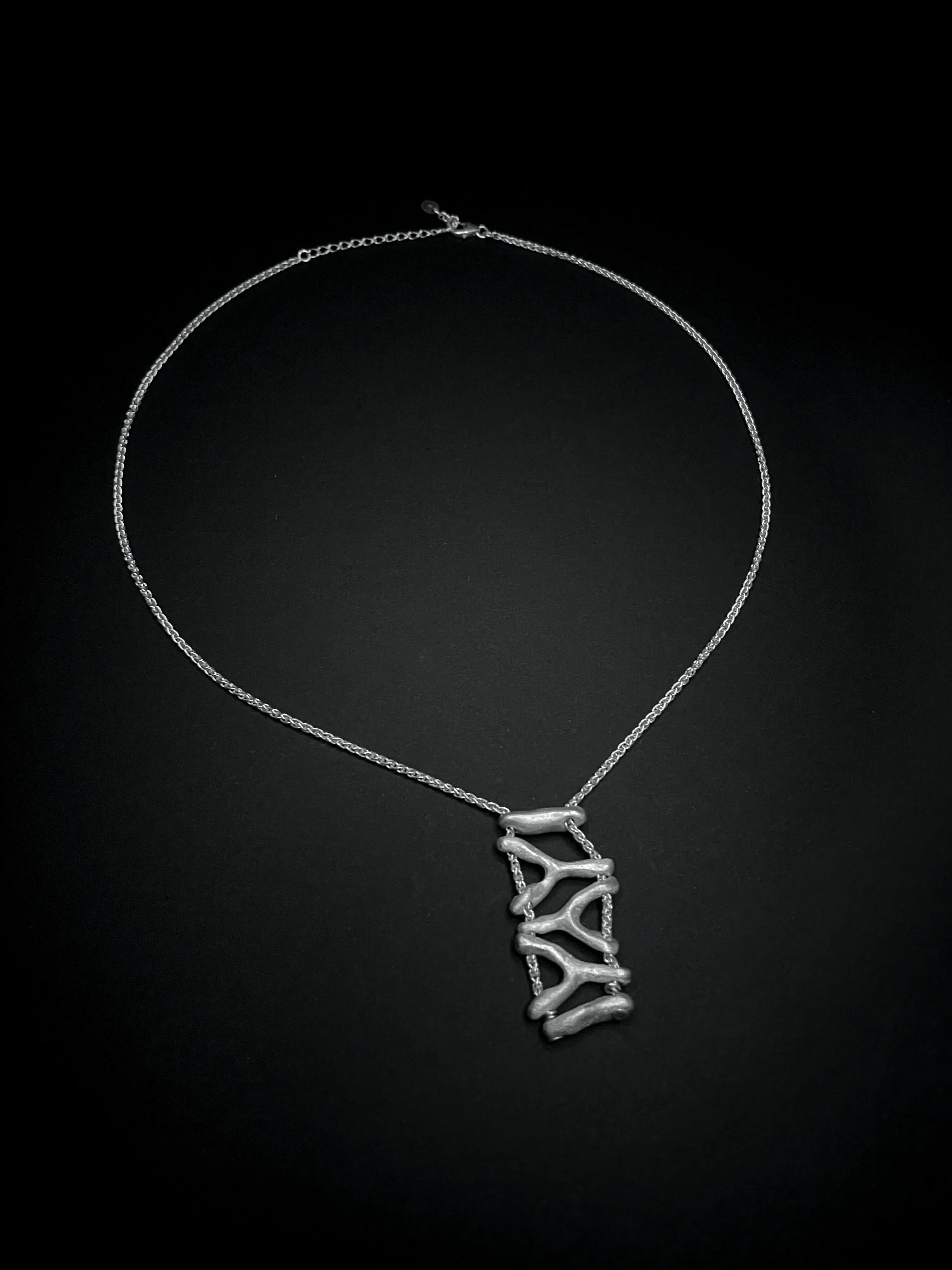 Pendentif du collier Isopora en argent avec détail de perles d'argent.