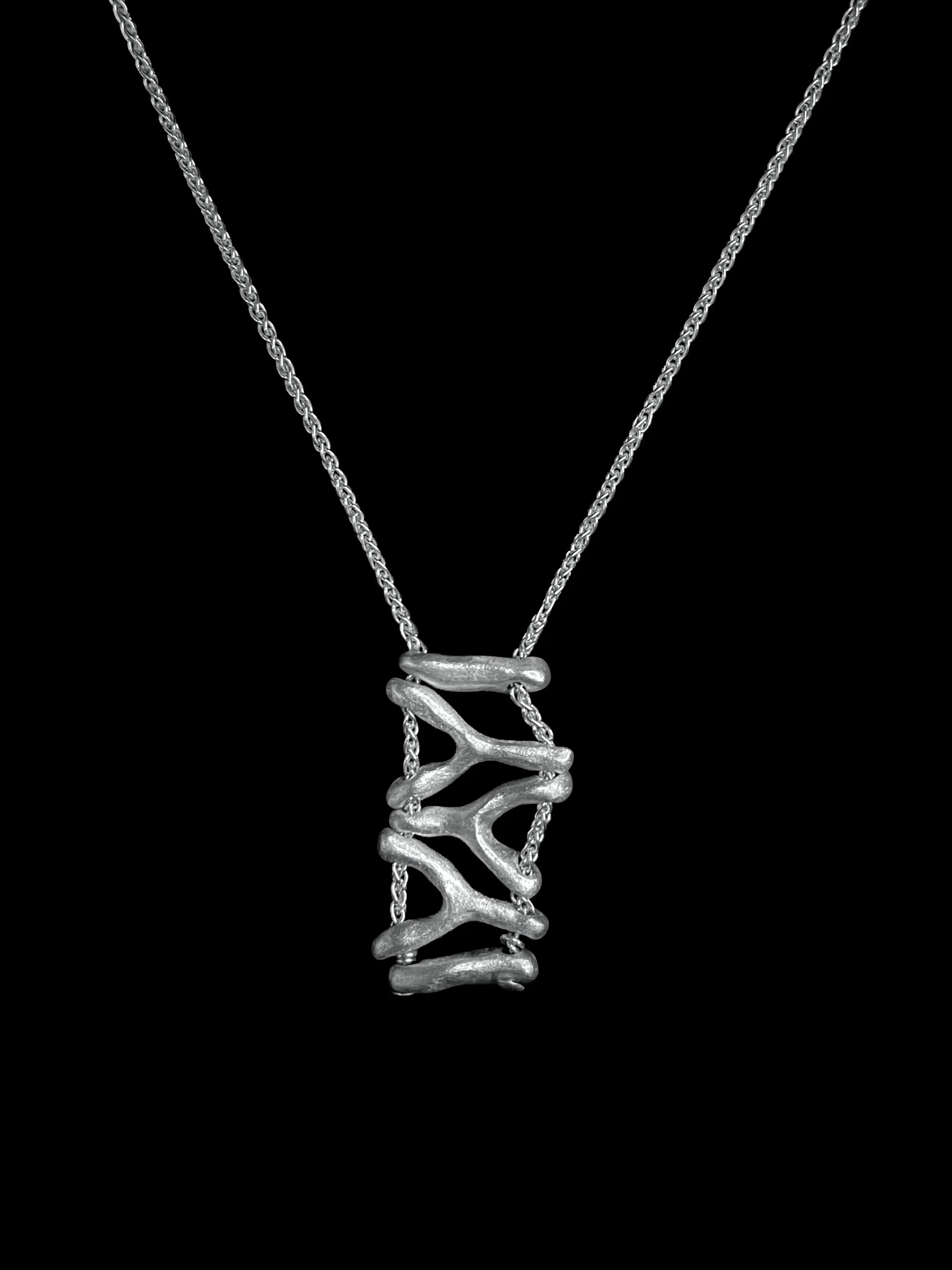 Vue produit du collier Isopora Synonys en argent 925 sur fond noir. Bijou fait main.
