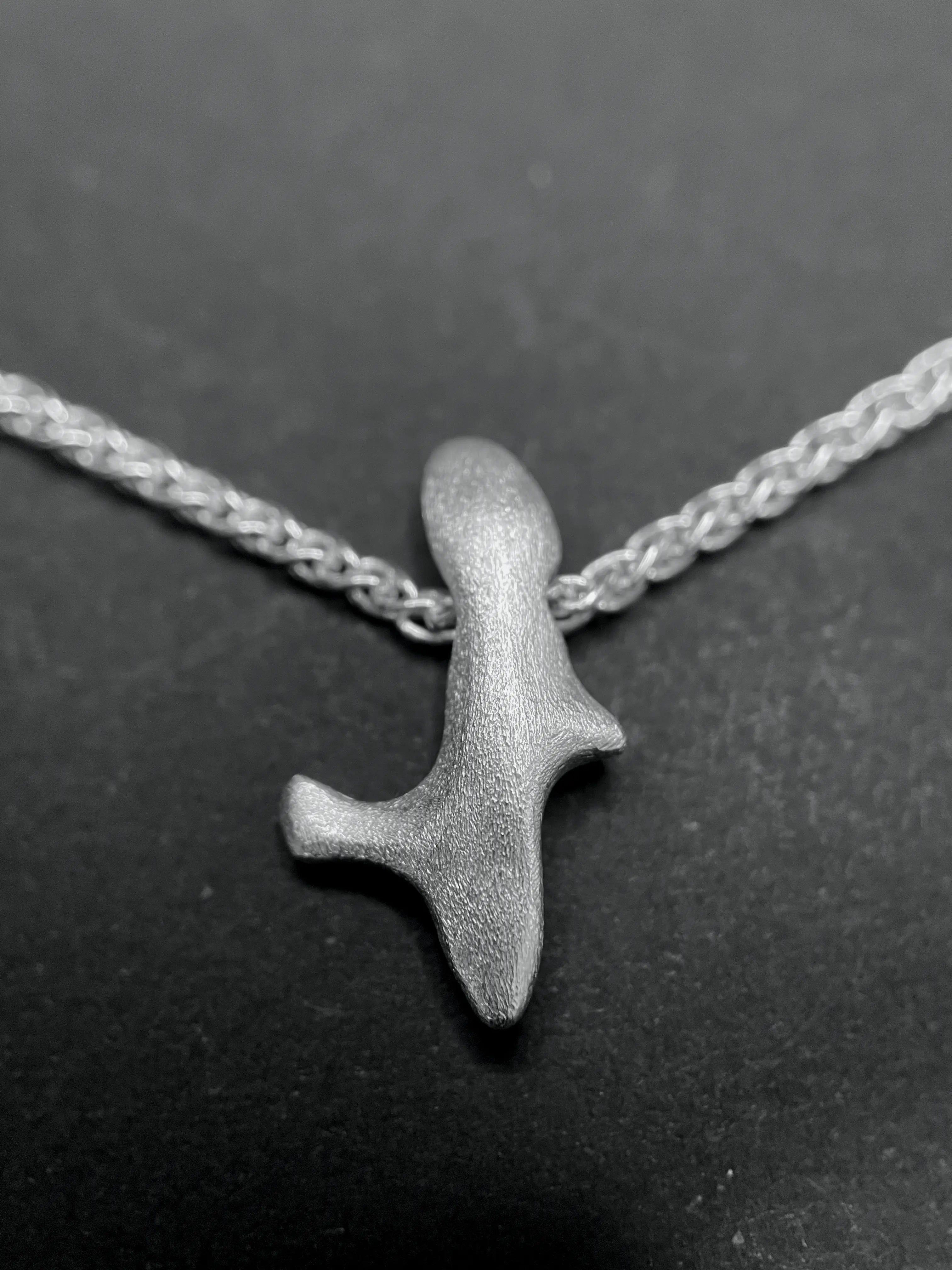 Macro du pendentif Skel en argent 925, mettant en valeur les lignes du design fait main.