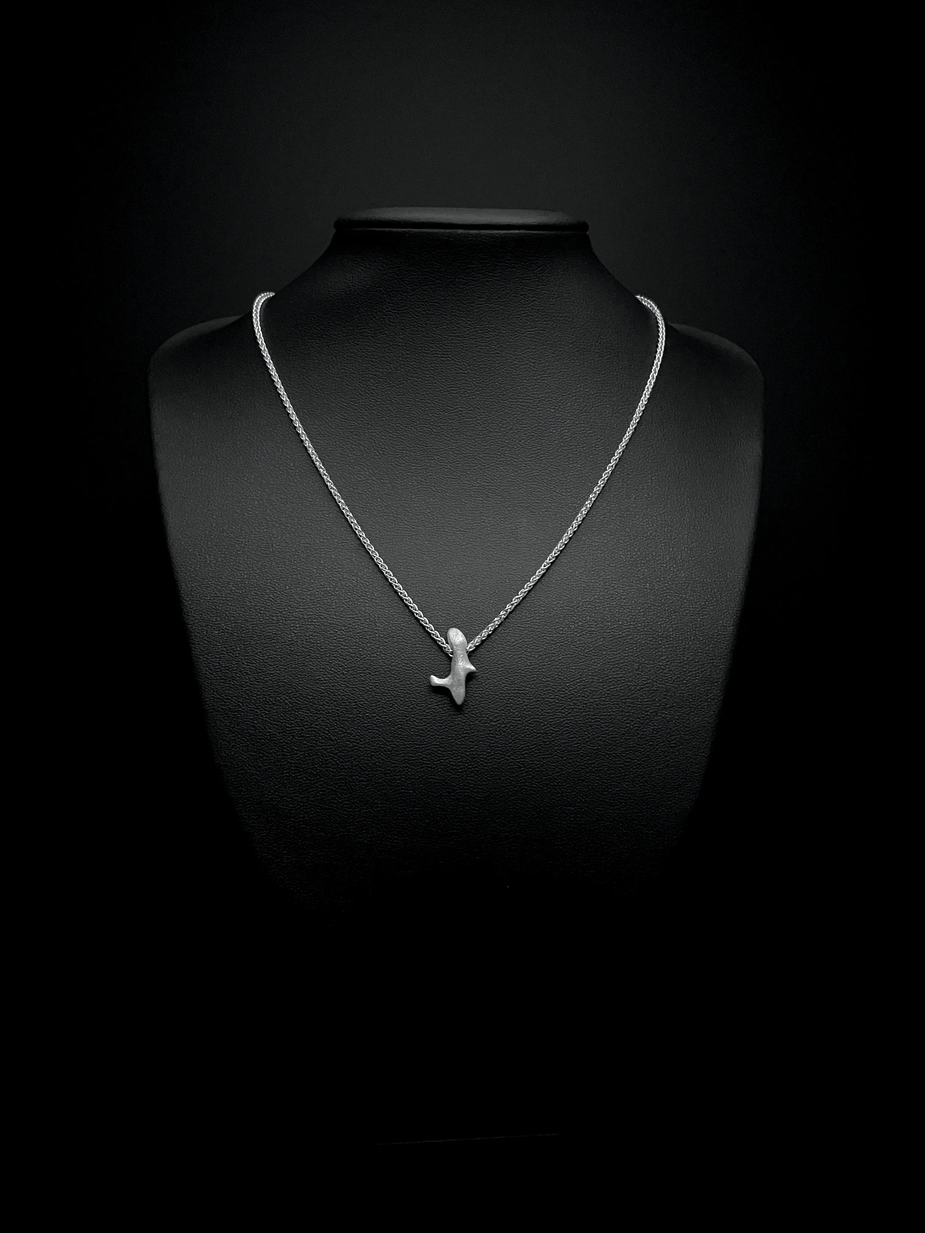 Collier Skel en argent porté sur un buste noir. Bijou éthique et élégant.