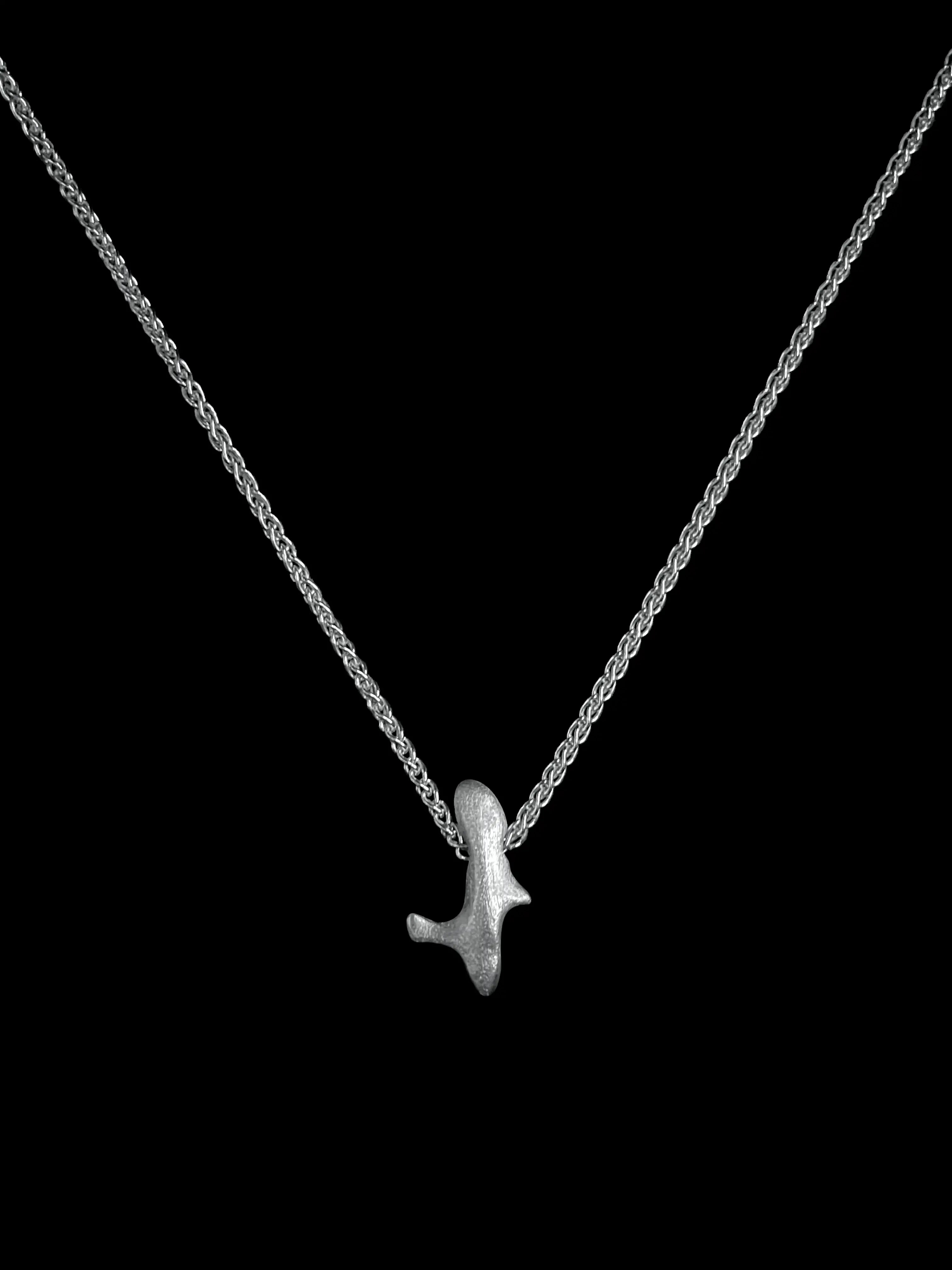 Vue produit du collier Skel sur fond noir. Bijou fait main de la collection Corail.